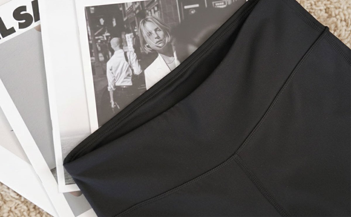 近距離拍攝 URBAN SPACE 瑜珈小喇叭褲的布料紋理，展示其特製的透氣針織結構與扎實的彈性手感，強調台灣開發製造的品質。